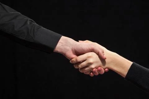 Handshake on a black background. Stock Photos