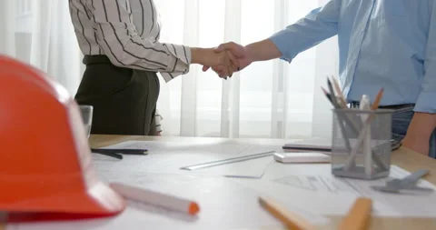 Handshake of a builder and a client with a helmet in the foreground. Partnership Stock Footage 201742746