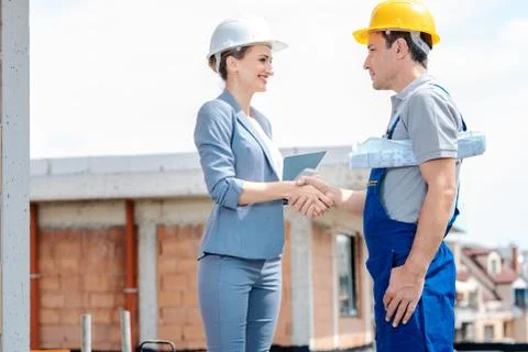 Handshake on construction site between developer and builder Stock Photos