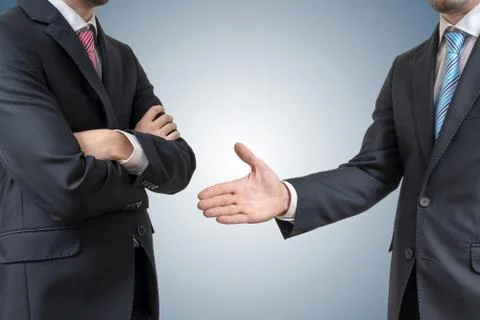 Handshake refuse. Man is refusing shake hand with businessman who is offering Stock-Fotos
