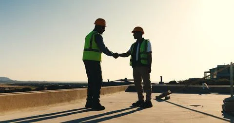 Handshake, success and construction worker team on rooftop for completion Stock Photos
