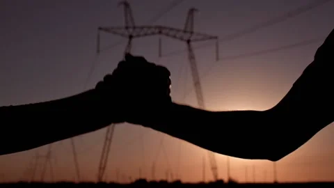 Handshake of two electrical engineers against the backdrop of high-voltage Stockbeeldmateriaal 204857726