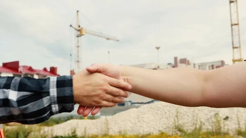 Handshake of two hands on the background of a construction site that show thumbs Stock Footage 129059973