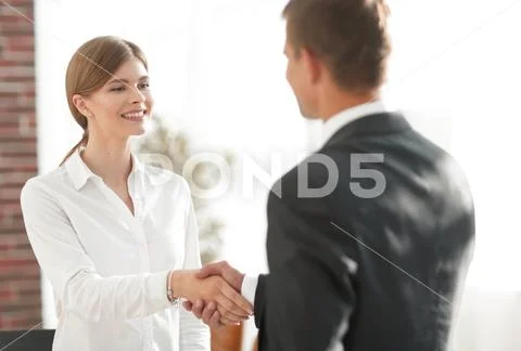 Handshake young business woman with a colleague Stock Photos