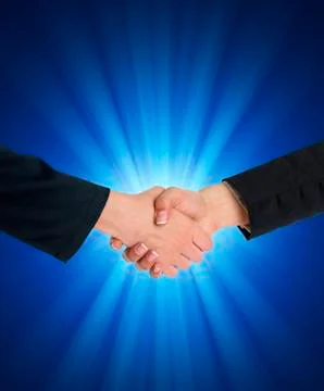 Handshaking in front of blue light Stock Photos
