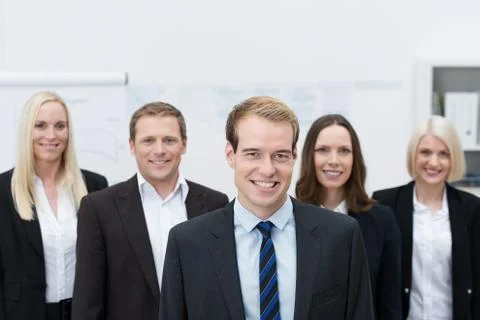Handsom young manager with a happy team behind him Stock Photos