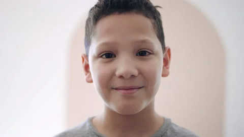 Handsome 10 year old hispanic boy looks to camera with contented smile 8K 스톡 동영상 194470734