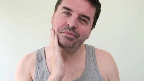 Handsome 40 years old middle aged bearded man apply skincare cream on face Stock Footage 129566908