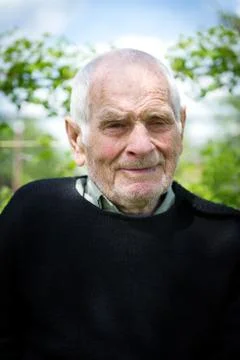 Handsome 80 plus year old senior man posing for a portrait in his garden. Stock Photos