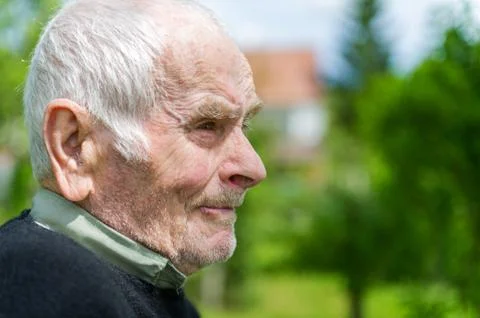 Handsome 80 plus year old senior man posing for a portrait in his garden. Stock Photos