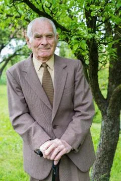 Handsome 80 plus year old senior man posing for a portrait in his garden. Stock Photos