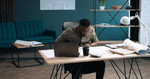 Handsome African-American Engineer is working in big modern Office on Blueprint Stock Footage 126235955