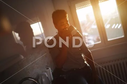 Handsome african american man drinking coffee in kitchen Stock Photos