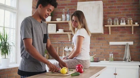 Handsome african guy preparing salad, cutting lemon and squeezing juice from it Stock Footage 81161886