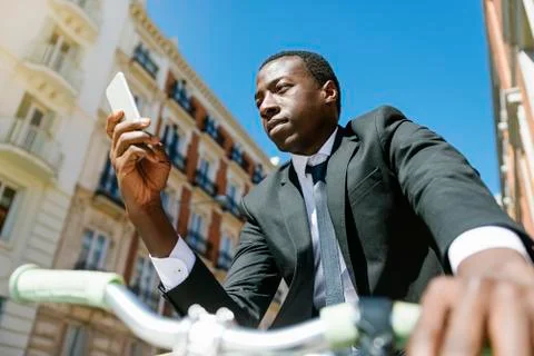 Handsome african man smiling when he is using his mobile. Stock Photos