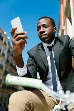 Handsome african man smiling when he is using his mobile. Stock Photos