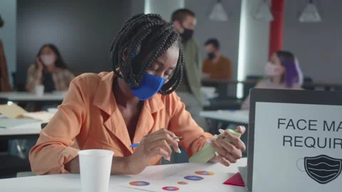 A handsome african professor is checking her students' homework and looking Stock Footage 175355328