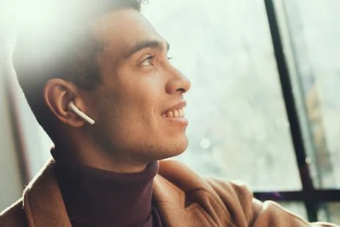 Handsome afro american guy using wireless earbuds Stock Photos