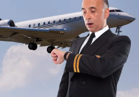 Handsome airline worker looking at his watch Stock Photos