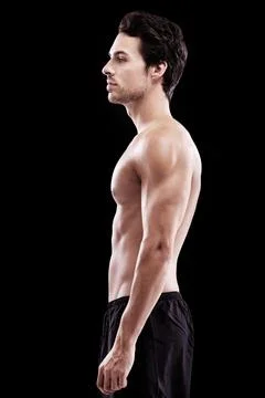 Handsome and brooding. Studio shot of a bare-chest and fit young man. Stock Photos