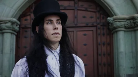 Handsome and mysterious gothic vampire with long black hair walking in the .. Stock Footage 284843980