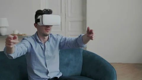 Handsome and stylish guy exploring and testing a virtual reality glasses indoor Stock Footage 107810794