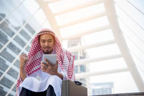 Handsome Arab Man Using Tablet computer while sitting in the city. Business s Stock Photos