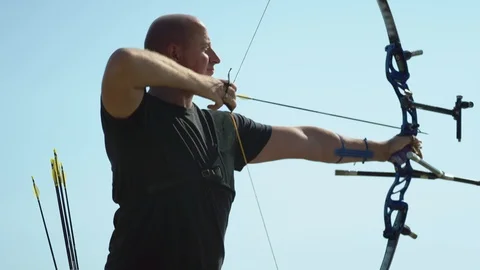 Handsome archer prepares to shoot an arrow from a bow Stock Footage 116025061