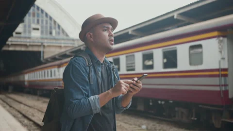 Handsome asian backpacker man waiting train on railway. Vídeos de archivo 218828213