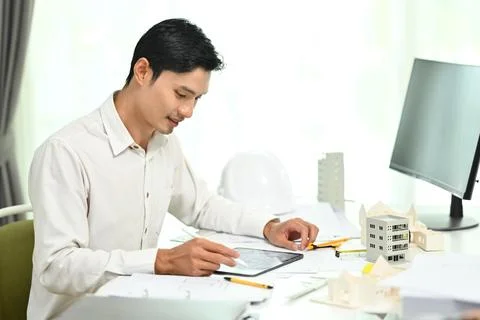 Handsome asian engineer man using digital tablet, working on construction Stock Photos