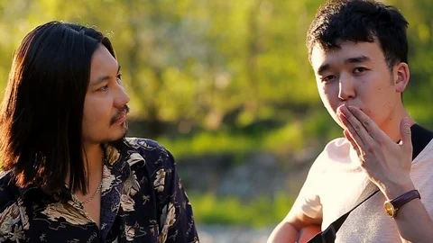 Handsome asian guy is teaching other guy to send air kisses Stock Footage 76017530