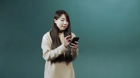 A handsome asian lady is using a phone and chatting with her friend Stock Footage 170800259