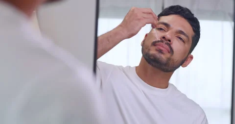 Handsome Asian man drops beard growth serum while standing in front of mirror. Stock Footage 270505342