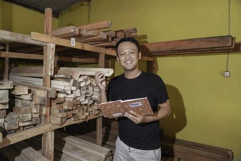 Handsome Asian Man is smiling while checking his carpentry workshop. Foto stock