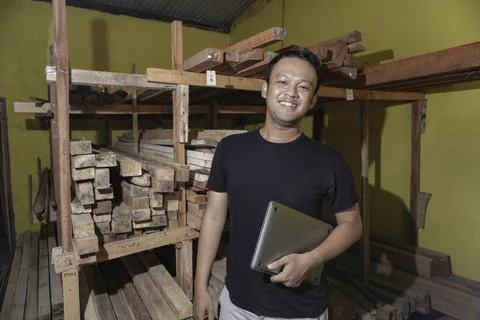 Handsome Asian Man is smiling while checking his carpentry workshop. Stock Photos