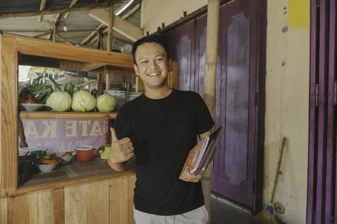 Handsome Asian Man is smiling while checking his satay kiosk. Stock Photos