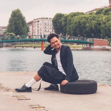 Handsome Asian model posing by an artificial basin Stock Photos