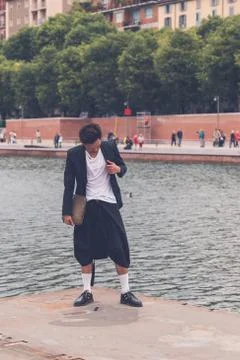 Handsome Asian model posing by an artificial basin Stock Photos