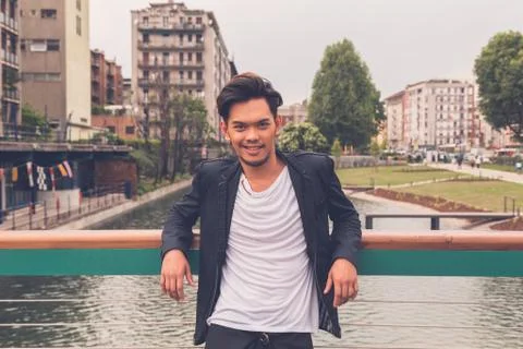 Handsome Asian model posing by an artificial basin Stock Photos