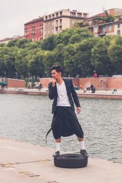 Handsome Asian model posing by an artificial basin Stock Photos