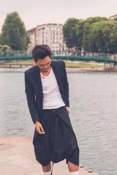 Handsome Asian model posing by an artificial basin Stock Photos