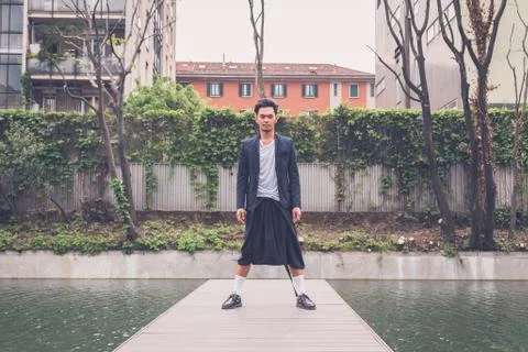 Handsome Asian model posing by an artificial basin Foto stock