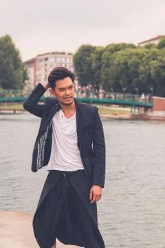 Handsome Asian model posing by an artificial basin Stock Photos