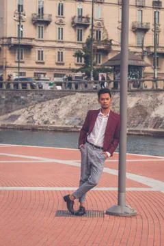 Handsome Asian model posing by an artificial basin Stock Photos