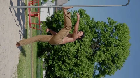 A handsome athlete with a bare torso and beige cargo pants is stretching. Vídeo Stock 246201036