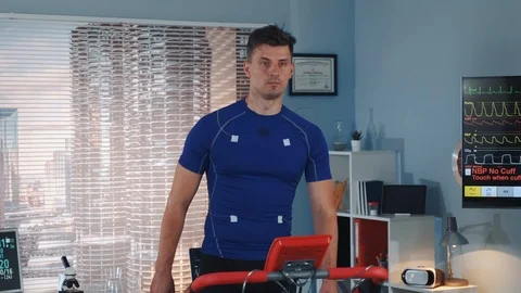 Handsome athlete walking on treadmill with electrodes connected on him Stock Footage 114076004