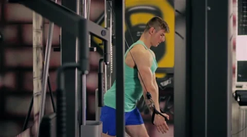 Handsome athletic guy doing pectorals on the crossover trainer in the GYM view f Stock Footage 63220603