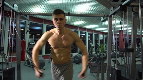 Handsome athletic guy doing pectorals on the crossover trainer in the gym. front Stock Footage 72502134