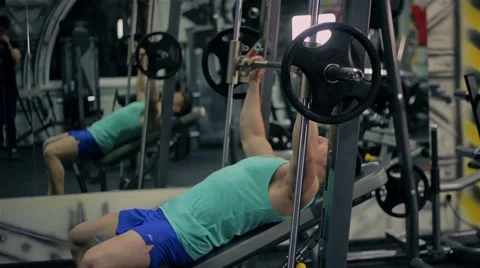 Handsome athletic man doing pectorals with bench press trainer with dumbbells on 库存影片 63217761