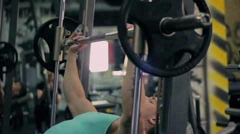Handsome athletic man doing pectorals with bench press trainer with dumbbells on Stock Footage 63217768